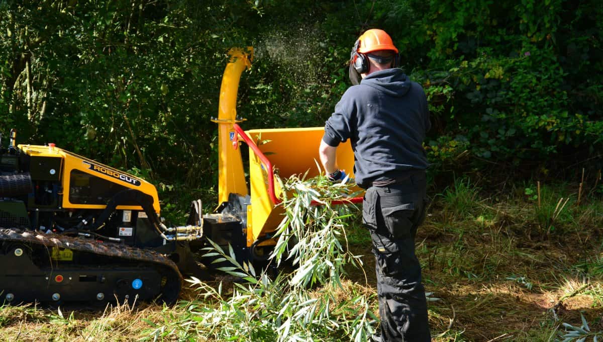 ROBO Chipper operator pushing leaves into the chipper