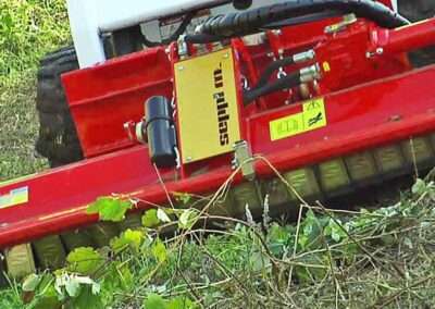 SMWA skid steer in action cutting along the ground